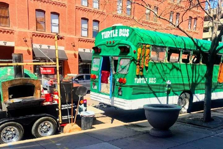 a green truck parked in front of a building